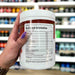 Close-up of (Per4m Pre Workout Stim 570g 30 Servings) held up inside My Supplement Shop, clearly showing Nutritional Values on the packaging in a Sports Nutrition setting.